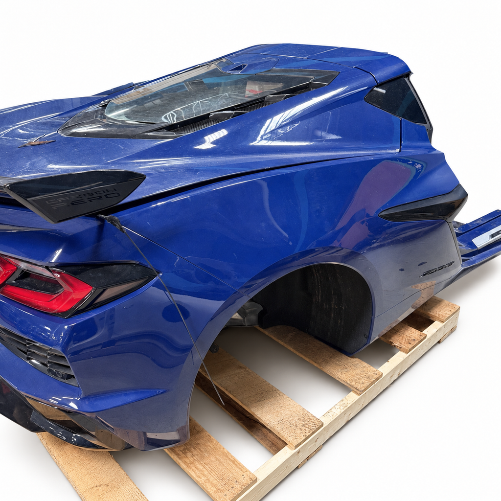 Chevrolet Corvette C8 Z06 blue rear clip assembly showing rear quarter panel, taillamp, fascia and high-wing spoiler; background cleaned