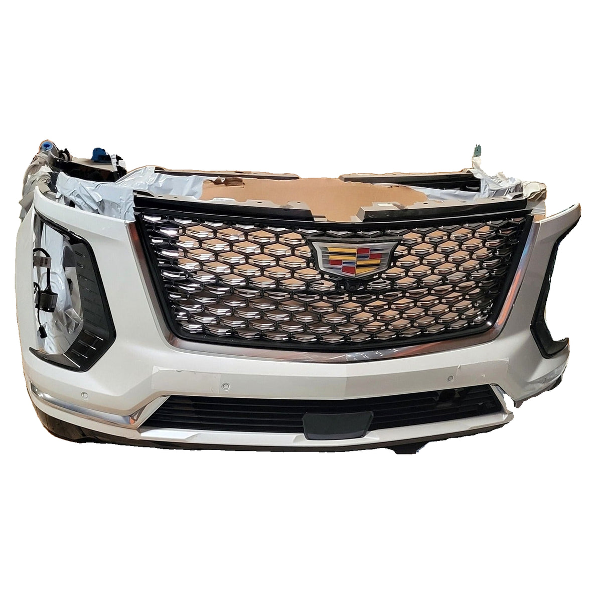 Original stock photo of Cadillac Escalade Luxury bumper assembly, showing grille, Abalone White 140X finish and protective wrapping