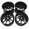 Four gloss-black Chevrolet Corvette forged wheels, two front and two rear, without tires or center caps