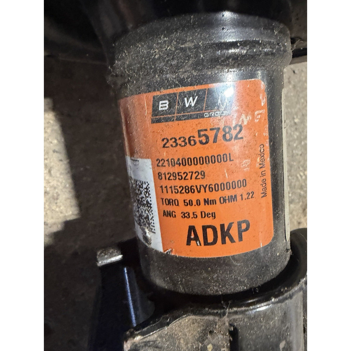 Original left front strut label showing GM part number 23365782